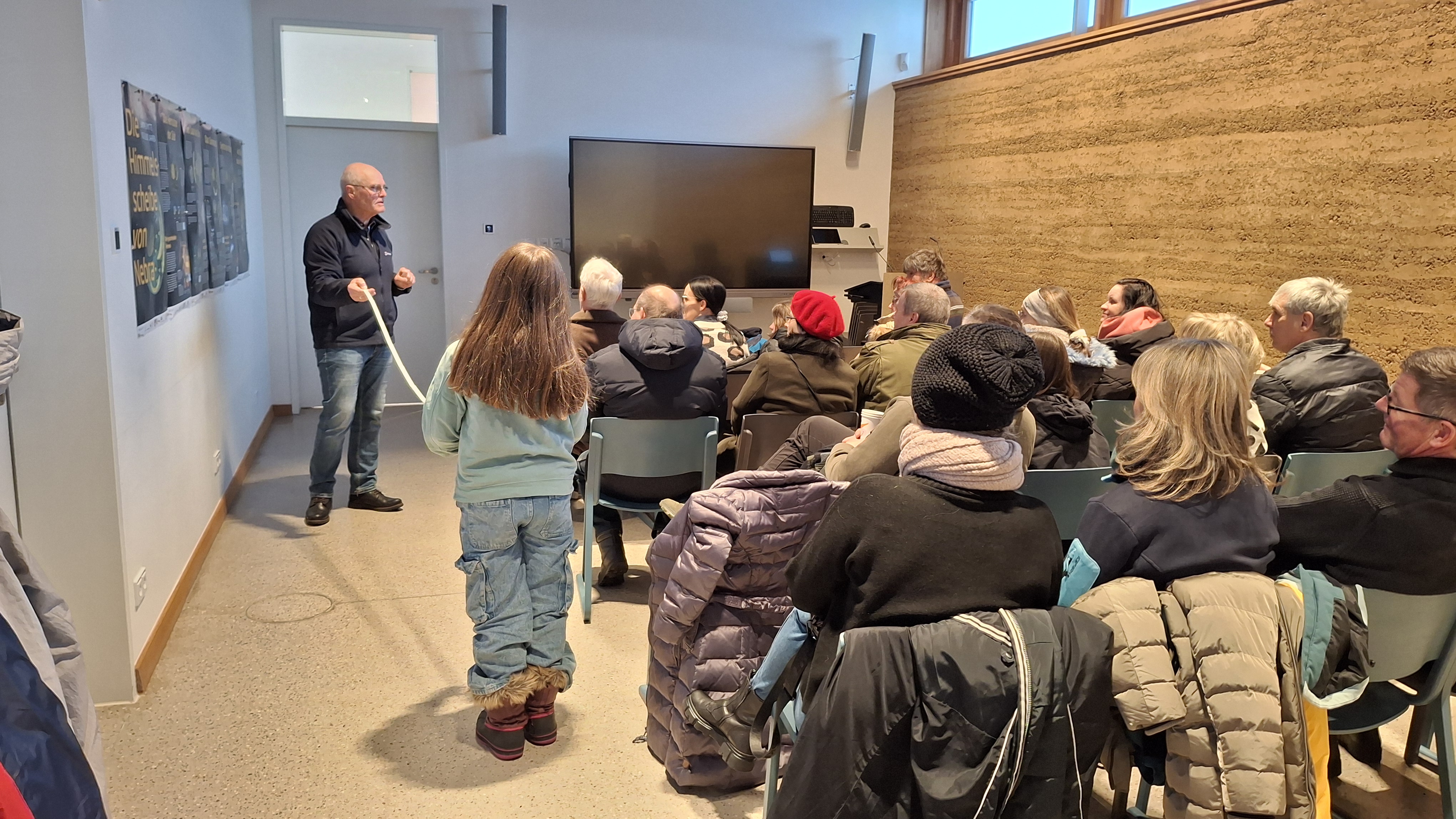 Eine Gruppe Menschen bekommt im Touristeninformationszentrum des Ringheiligtums eine Einführung in das Thema Lichtmess und Ringheiligtum. 