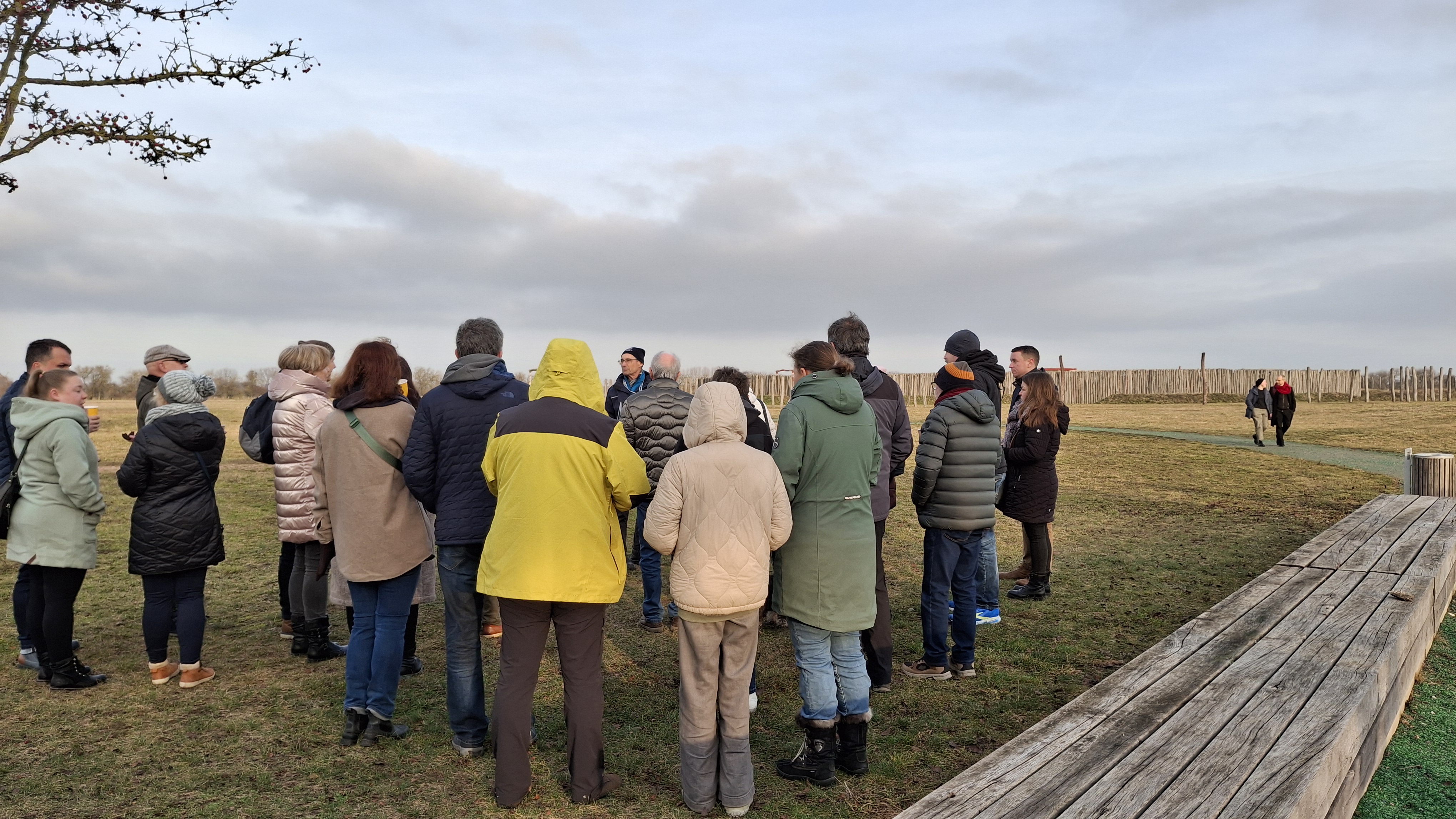 Eine Gruppe Menschen steht vor dem Ringheiligtum und nimmt an einer Gästeführung teil.