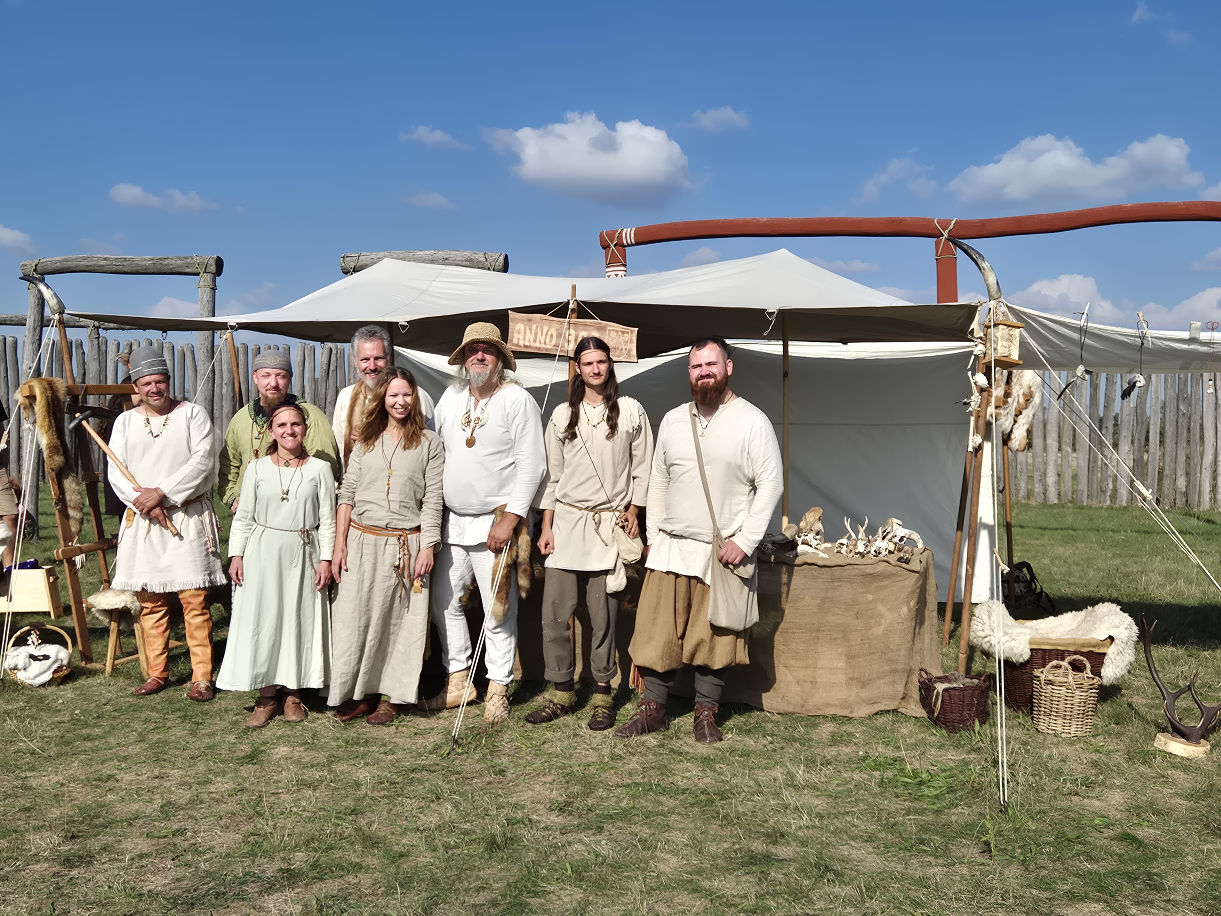 Eine Gruppe Menschen in altertümlicher Kleidung steht lächelnd inmitten des Ringheiligtums. 